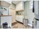 Neat laundry area with storage and updated appliances, a door that leads outside, and wood-look vinyl floors at 6956 Oakstone Pl, Charlotte, NC 28210