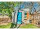 Backyard shed with a colorful door, window with shutter, and tidy wood storage at 6956 Oakstone Pl, Charlotte, NC 28210