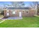 The backyard boasts a brick home exterior, a concrete patio, and a level lawn at 7124 Brynhurst Dr, Charlotte, NC 28210
