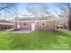 The backyard boasts a brick home exterior, a concrete patio, and a level lawn at 7124 Brynhurst Dr, Charlotte, NC 28210
