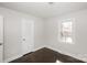 This bedroom features neutral walls, dark wood-look floors, a closet, and a bright window at 7124 Brynhurst Dr, Charlotte, NC 28210
