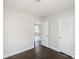 This bedroom offers neutral walls, dark wood-look floors, a closet, and a doorway to another room at 7124 Brynhurst Dr, Charlotte, NC 28210
