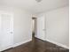 This bedroom features neutral walls, dark wood-look floors, a closet, and a doorway to another room at 7124 Brynhurst Dr, Charlotte, NC 28210