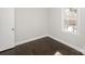 This bedroom offers neutral walls, dark wood-look floors, and a bright window with view at 7124 Brynhurst Dr, Charlotte, NC 28210