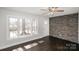 Bright living room featuring dark wood floors and brick accent wall at 7124 Brynhurst Dr, Charlotte, NC 28210