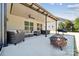 Spacious covered patio with comfortable seating, dining area, and a fire pit, perfect for outdoor gatherings at 8310 Sandstone Crest Ln, Indian Land, SC 29707