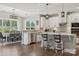 Open kitchen with white cabinets, an island with bar seating, stainless steel appliances, and an adjacent dining area at 8310 Sandstone Crest Ln, Indian Land, SC 29707