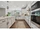 Well-lit kitchen with white cabinetry, stainless steel appliances, an island with quartz countertops, and wood floors at 8310 Sandstone Crest Ln, Indian Land, SC 29707