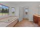 Bathroom features jetted tub, ceramic floors, windows, and a wooden vanity with marble countertop at 1030 Hurley School Rd, Salisbury, NC 28147