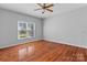 Bedroom features hardwood floors, neutral walls, a ceiling fan, and one large window at 1030 Hurley School Rd, Salisbury, NC 28147