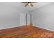 Bedroom features hardwood floors, neutral walls, a ceiling fan, and two white doors at 1030 Hurley School Rd, Salisbury, NC 28147