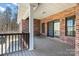 Covered deck with brick siding, wood flooring, and a built-in bench at 1030 Hurley School Rd, Salisbury, NC 28147