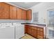 Laundry room with washer, dryer, wood cabinets, utility sink and wood look flooring at 1030 Hurley School Rd, Salisbury, NC 28147