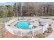 Aerial view of a fenced in in-ground swimming pool with clear blue water and a spa attached at 1030 Hurley School Rd, Salisbury, NC 28147