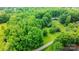 Aerial view of wooded property featuring a home with a pool and landscaping at 1080 Rolling Green Dr, Newton, NC 28658