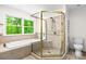 Beautiful bathroom with a glass enclosed shower, soaking tub and a window with green scenery at 1080 Rolling Green Dr, Newton, NC 28658