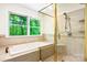 Bright bathroom features a tiled shower, bathtub, and large window with green outdoor views at 1080 Rolling Green Dr, Newton, NC 28658