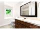 Bathroom with a single vanity, toilet, and large mirror with a window letting in natural light at 1080 Rolling Green Dr, Newton, NC 28658
