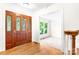 Inviting foyer with hardwood flooring, decorative front door, and open view into the carpeted living room at 1080 Rolling Green Dr, Newton, NC 28658