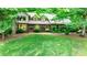 Charming brick home with lush landscaping and mature trees in a serene, wooded setting, offering a welcoming curb appeal at 1080 Rolling Green Dr, Newton, NC 28658