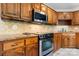 Close-up of the kitchen with modern stainless steel appliances and natural wood cabinets at 1080 Rolling Green Dr, Newton, NC 28658