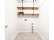 A bright laundry room with tile floor and wooden shelving at 1080 Rolling Green Dr, Newton, NC 28658
