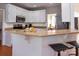 Kitchen bar with granite countertop, white cabinets, stainless steel appliances, and bar seating at 10845 Hellebore Rd, Charlotte, NC 28213