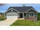 Charming single-story home featuring a two-car garage, stone accents and a welcoming front porch at 111 High Rock Ct # 10, Statesville, NC 28677