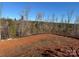 The cleared lot on a home site displays freshly tilled red clay dirt and views of a dense line of trees at 121 High Rock Ct # 08, Statesville, NC 28677