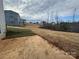 View of the grassy and cleared backyard with an adjacent house and a partially poured concrete patio at 121 High Rock Ct # 08, Statesville, NC 28677
