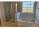 Bright bathroom featuring a shower, soaking tub, and large window at 121 High Rock Ct # 08, Statesville, NC 28677