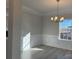 Bright dining room features elegant wainscoting, modern chandelier, and large window for natural light at 121 High Rock Ct # 08, Statesville, NC 28677