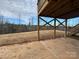 The backyard features a concrete patio area with supporting beams from the deck above and a partially cleared lot at 121 High Rock Ct # 08, Statesville, NC 28677