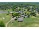An aerial view highlights the clubhouse and surrounding golf course, showcasing its beautiful landscape at 13358 Bally Bunnion Way, Davidson, NC 28036
