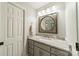 Well-lit bathroom with a gray vanity, granite countertop, and a round mirror at 13358 Bally Bunnion Way, Davidson, NC 28036