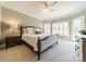 Bright bedroom with a large bed, neutral colors, and a ceiling fan that promotes relaxation at 13358 Bally Bunnion Way, Davidson, NC 28036
