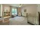 Cozy Bedroom with a crib, rocking chair, dresser, and rug at 13358 Bally Bunnion Way, Davidson, NC 28036