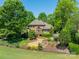 Beautiful brick home with manicured landscaping, mature trees, and a charming water feature at 13358 Bally Bunnion Way, Davidson, NC 28036