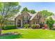 Beautiful brick home featuring professional landscaping and a welcoming front lawn at 13358 Bally Bunnion Way, Davidson, NC 28036