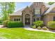 Brick home with a well-manicured lawn and beautiful, mature landscaping at 13358 Bally Bunnion Way, Davidson, NC 28036