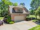 Brick home featuring a detached two-car garage and a view of the golf course at 13358 Bally Bunnion Way, Davidson, NC 28036