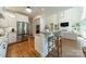 Open-concept kitchen featuring white cabinetry, granite countertops, and stainless steel appliances at 13358 Bally Bunnion Way, Davidson, NC 28036