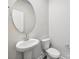 A half bath featuring a pedestal sink, oval mirror, and modern fixtures at 150 Aberdeen Dr, Salisbury, NC 28144