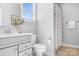 Bright bathroom featuring a vanity, toilet, and a shower with a patterned curtain at 152 Broadleaf Dr, Denver, NC 28037