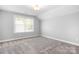 Neutral-toned bedroom featuring carpeted floors, white trim, window and ceiling light at 152 Broadleaf Dr, Denver, NC 28037