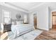 Bright bedroom features tray ceilings, modern lighting, wood floors, and ensuite bathroom access at 152 Broadleaf Dr, Denver, NC 28037