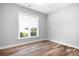 A blank canvas bedroom features hardwood floors and a window view at 152 Broadleaf Dr, Denver, NC 28037