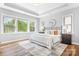 Bright bedroom featuring large windows, hardwood floors, and a tray ceiling design at 152 Broadleaf Dr, Denver, NC 28037