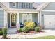 Inviting front porch featuring stone accents and stylish outdoor seating, framed by beautiful landscaping at 152 Broadleaf Dr, Denver, NC 28037