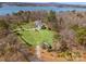 Aerial view of a beautiful home with a well-maintained lawn and a picturesque lake in the background at 16455 Harbor View Rd, Charlotte, NC 28278